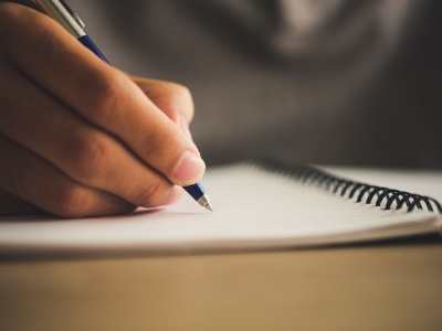 Man hand with pen writing on notebook.